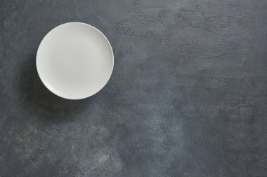 Beyaz boş tabak, dekoratif desenli peçete. Yukarı görünüm.