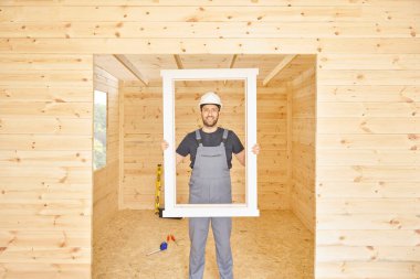 İnşaatçı, inşaatçı yeni ahşap ev yapar, küçük ev tarzı. Ruh seviyesi, vida, alet çantası ve dolu matkap. Ahşap sitili.