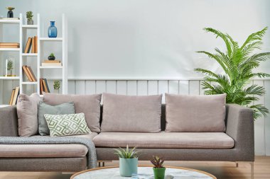 Gri kanepe ve beyaz duvar arkaplanı kitaplık ve orta masa tarzı, iç mekan.