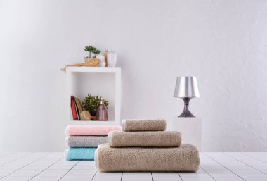 Kahverengi ve renkli havlu sıranın arkasında, beyaz duvar ve dolap arka plan duvarı, banyo nesnesi.