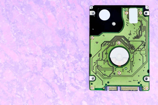 a high-capacity, self-contained storage device containing a read-write mechanism plus hard disks, inside a sealed unit. Internal hard drive for storing information on a pink lilac sandy surface