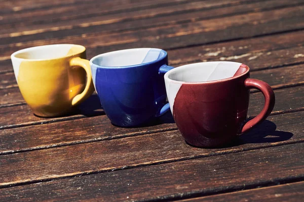 Niebieski Żółto Czerwone Filiżanki Herbaty Kawy Brązowej Drewnianej Powierzchni Słoneczny — Zdjęcie stockowe
