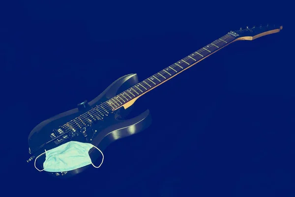 Guitarra Elétrica Escura Com Uma Máscara Protetora Fundo Preto — Fotografia de Stock