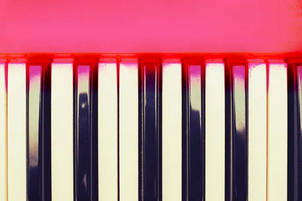 White and black musical keys of piano synthesizer with pink space for text