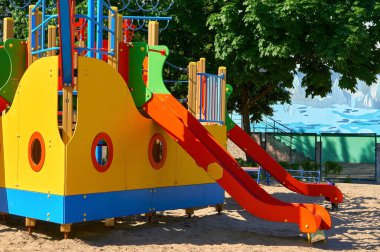 Summer spring children's playground with painted toy ship in park                              