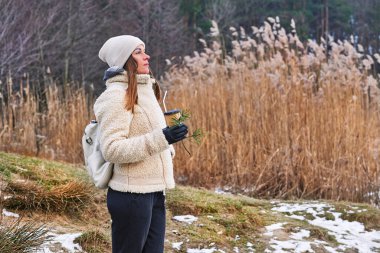   Young pretty woman enjoy the peace quiet of the spring winter forest with coffee                             