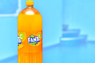 Kyiv, Ukrayna, 22 Haziran 2022. Bir şişe lezzetli portakallı gazoz Fanta mavi üzerinde