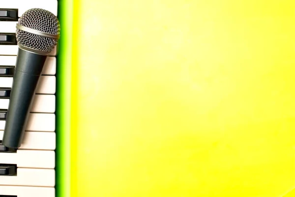 黄色背景上的钢琴合成器键和话筒 — 图库照片