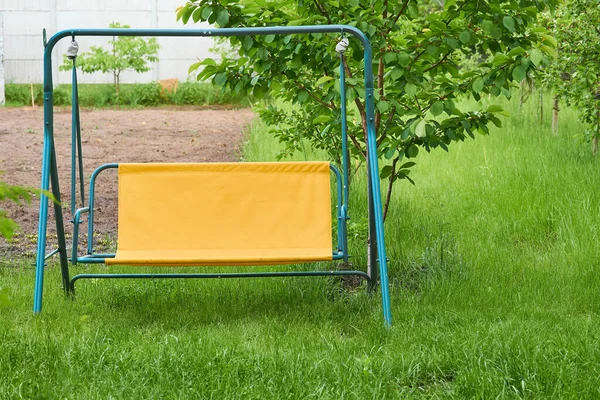 緑の芝生の上で夏の春のプロットに休んで リラックスのための庭の金属スイング — ストック写真