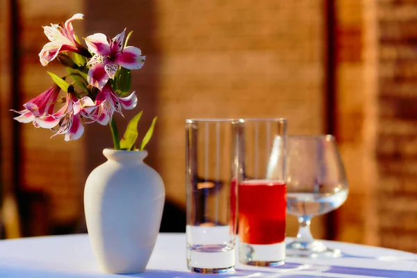 日落时分 院子里桌上放着花和眼镜的花瓶 — 图库照片