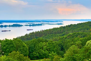 Yaz mevsimi akşamı nehir. Dniper, çiçek açan yeşil tepelerin arasında akıyor..                               