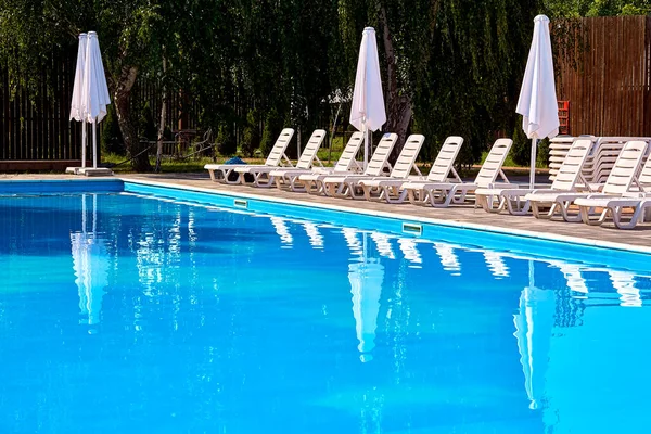 stock image Summer outdoor pool at the resort with sun loungers waiting for people to swim                               