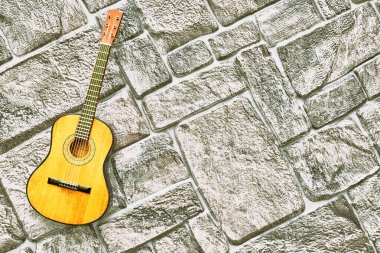 Dumanlı gri kaldırım tuğlası yüzeyinde sarı akustik gitar                              