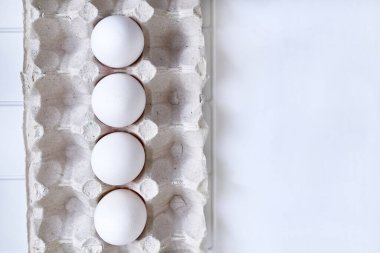 Plastik kareli bir rafta buzdolabında dört taze tavuk yumurtası.                               