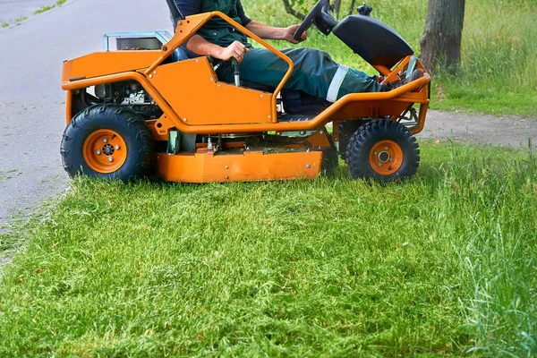 Professional grass cutting on lawns with a mini tractor lawn mower.