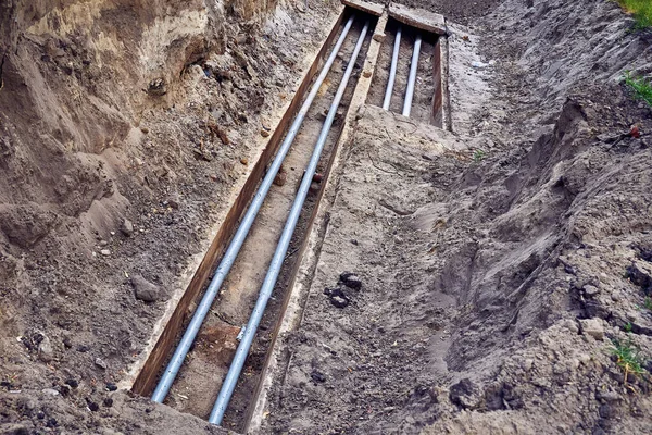 Tamir ve kurulum için plastik kanalizasyon borularıyla kazılmış bir çukur.                               