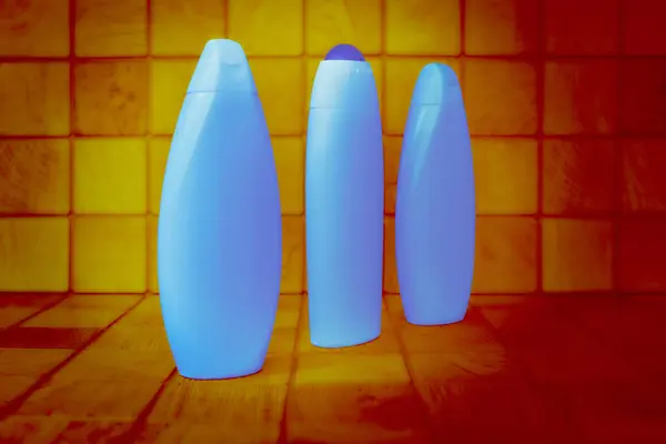 Plastic Blue Glowing Bottles Detergents Orange Wood Background Squares — Stock Photo, Image