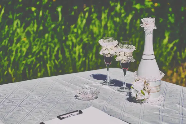 在夏季公园举行婚礼的装饰品和带眼镜的香槟 — 图库照片