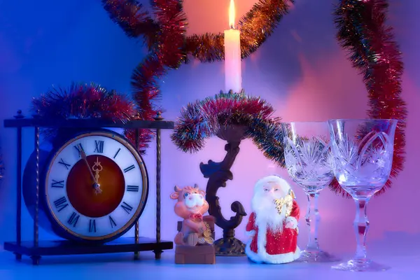 Santa Claus. vintage clock, wine glasses, burning candle in a candlestick, dusk