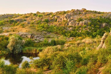 Tepeler. Sıcak yeşil vadi patika ve nehir güneş ışığıyla dolu.                              
