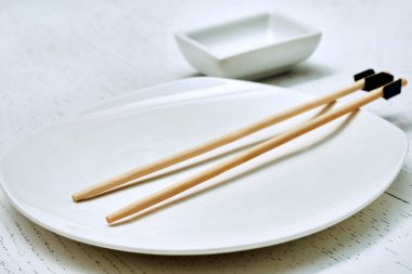 Beceriksizler için yapışkan çubuklar. Doğu yemeği, suşi, tabak, sos kasesi.