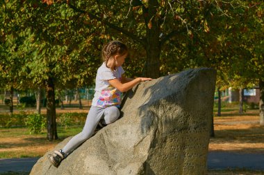 Çocuk duyguları. Şehir parkında bir taşın üzerinde oturan bir çocuğa hakaret                               