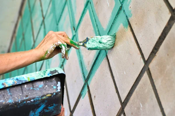 Painter's hands, tray with paint and brush.Painting the wall