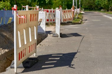 Tesisat boruları döşenirken kazılmış bir çukurun plastik çiti.                               