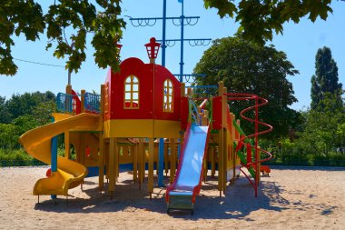 Yaz baharı çocukların oyun parkında boyalı oyuncak kaydırağıyla parkta                               