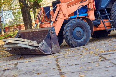 Kazıcı buldozer yol onarımı için eski beton levhaları yüklüyor                               