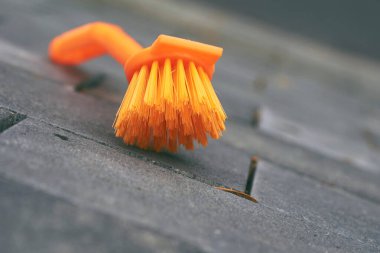Temizlik için turuncu fırça. Taş kiremitler, asfalt