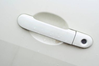 Kilitli beyaz araba kolu, yağmurdan sonra anahtar deliği