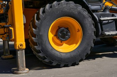 Kamyon vinci duraklarda duruyor, büyük bir traktör tekerleği.