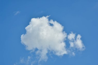 Beyaz bulutlar arka plan için mavi gökyüzüne karşı. Kabarık beyaz bulutlar gündüz gökyüzüne karşı. Cumulus pamuk yumağı gibi yumuşak bir buluttur.