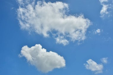 Beyaz bulutlar arka plan için mavi gökyüzüne karşı. Kabarık beyaz bulutlar gündüz gökyüzüne karşı. Cumulus pamuk yumağı gibi yumuşak bir buluttur.