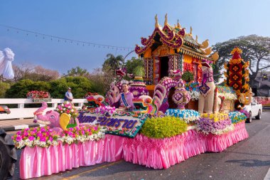 CHIANG MAI, THAILAND - FEBRUARY 04 , 2023  : A car decorated with fresh flowers in the parade of the 46th Chiang Mai Flower Festival moving through Nawarat Bridge Chiang Mai,Thailand.