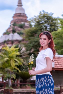 Geleneksel kostümlü genç Asyalı kadınlar Tayland 'da eski bir tapınağı ziyaret ediyorlar. Turist antik siteleri ziyaret ediyor.