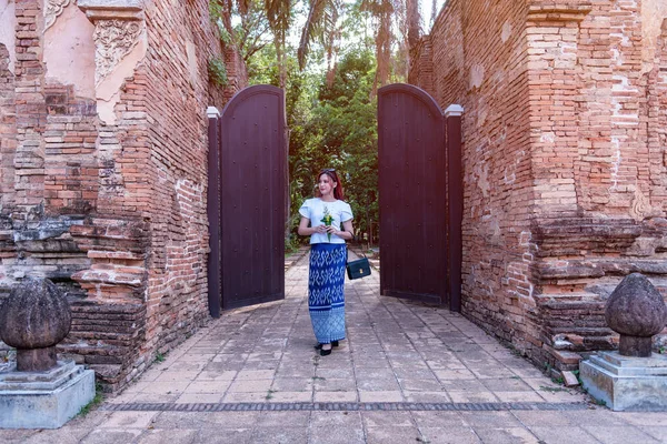 stock image Young Asian women dressed in traditional costumes visit an old temple in Thailand. Tourist visit ancient sites concept.