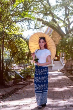 Geleneksel kostümlü genç Asyalı kadınlar Tayland 'da eski bir tapınağı ziyaret ediyorlar. Turist antik siteleri ziyaret ediyor.