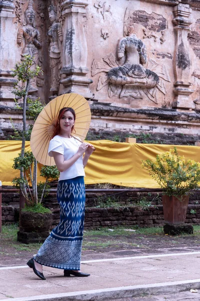 身穿传统服装的年轻亚洲妇女参观了泰国的一座古寺 游客参观古迹概念 — 图库照片