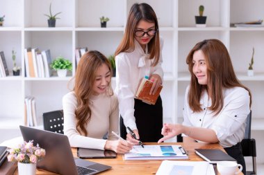 Üç Asyalı iş kadını Modern Ofis 'te yeni bir Fikir Sunumu projesini tartışıyor. Asya iş gündelik konsepti.