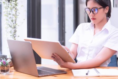 Ofiste dizüstü bilgisayarın önünde çalışan Asyalı bir iş kadını. Asya iş gündelik konsepti.