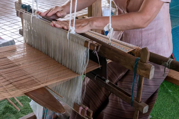 stock image The traditional weaving of handmade cotton on the manual wood loom in Thailand. Close up Handmade weaving traditional cloth mature Asian woman