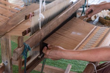 Geleneksel el yapımı pamuk dokuması Tayland 'da elle ahşap dokuma tezgahında. Geleneksel Asyalı kadın el yapımı örgü örüyor.