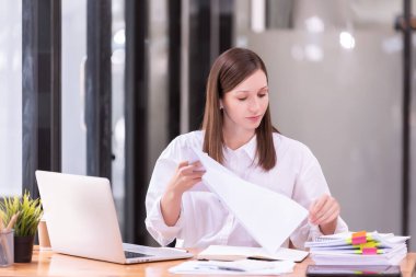 Ofiste dizüstü bilgisayarın önünde çalışan bir iş kadını. Ticaretin gelişigüzel ve başarılı kavramı