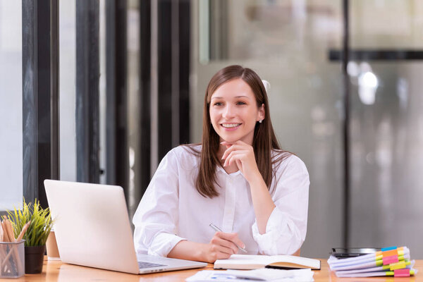 Businesswoman working in front of a laptop in the office. Business's casual and successful concept