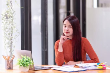 Ofiste dizüstü bilgisayarın önünde çalışan Asyalı bir iş kadını. Asya iş gündelik konsepti.