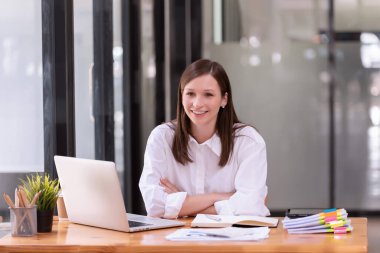 Ofiste dizüstü bilgisayarın önünde çalışan bir iş kadını. Ticaretin gelişigüzel ve başarılı kavramı