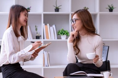 Modern Ofis 'te yeni bir Fikir Sunumu projesini tartışan iki genç Asyalı iş kadını. Asya iş gündelik konsepti.