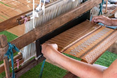 Geleneksel el yapımı pamuk dokuması Tayland 'da elle ahşap dokuma tezgahında. Geleneksel Asyalı kadın el yapımı örgü örüyor.